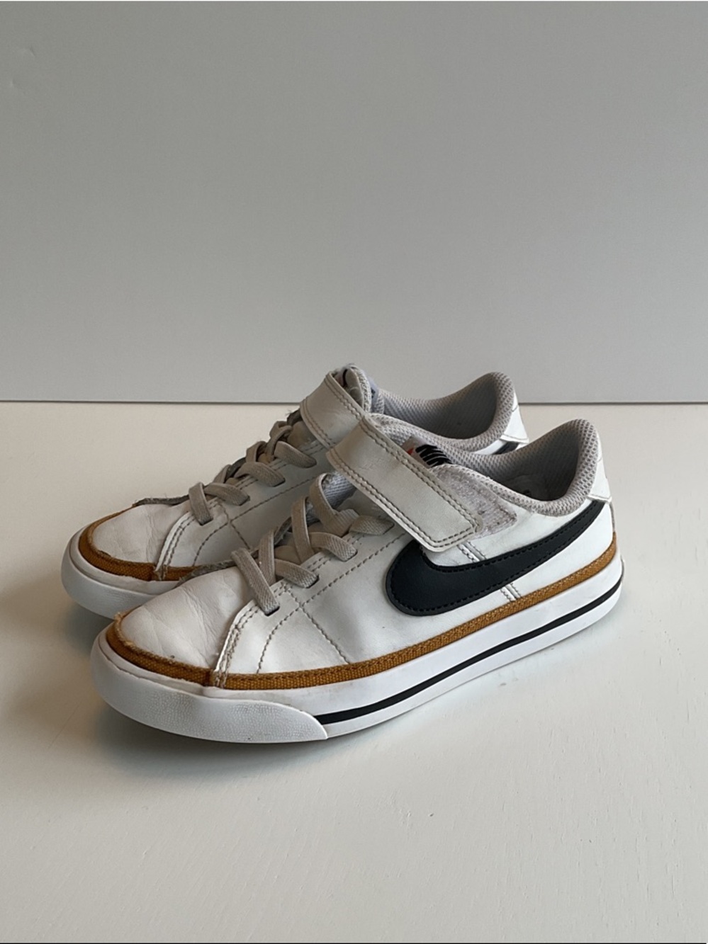 Nike Kids White Sneakers with Black Swoosh and Brown Accent